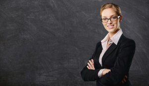 teacher smiling at blackboard